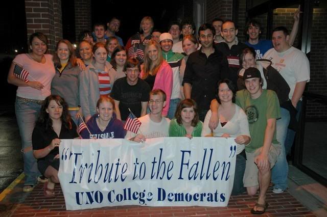 UNO College Democrats who put in a fell 5 hours putting up flags pose for a group photo at the end of the night